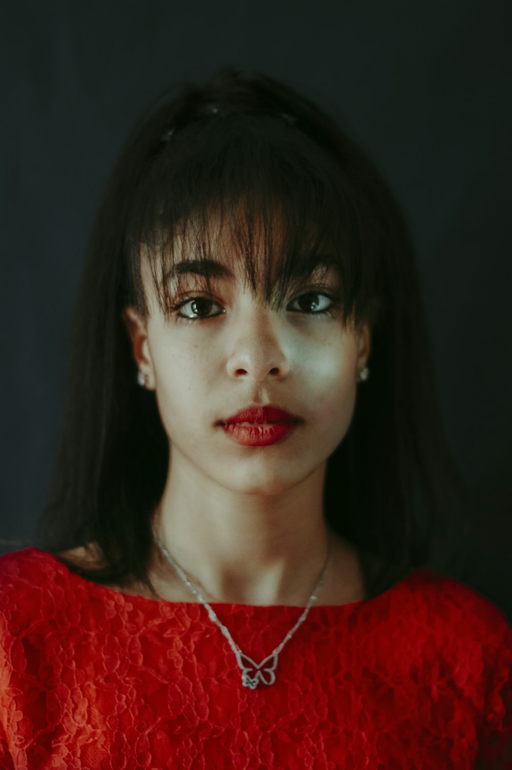 woman in red shirt wearing silver necklace