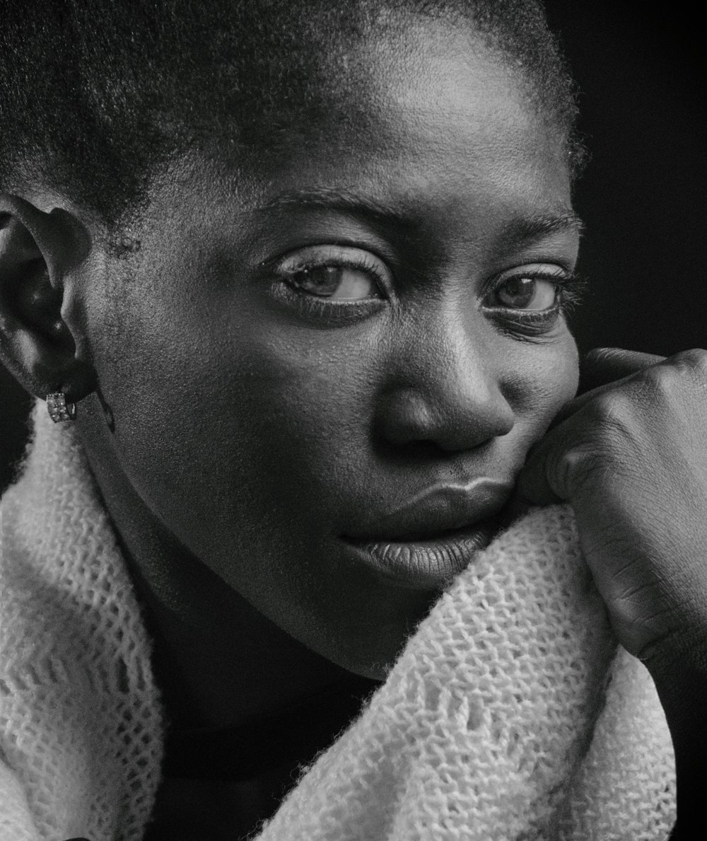 grayscale photo of woman covering her face with white textile