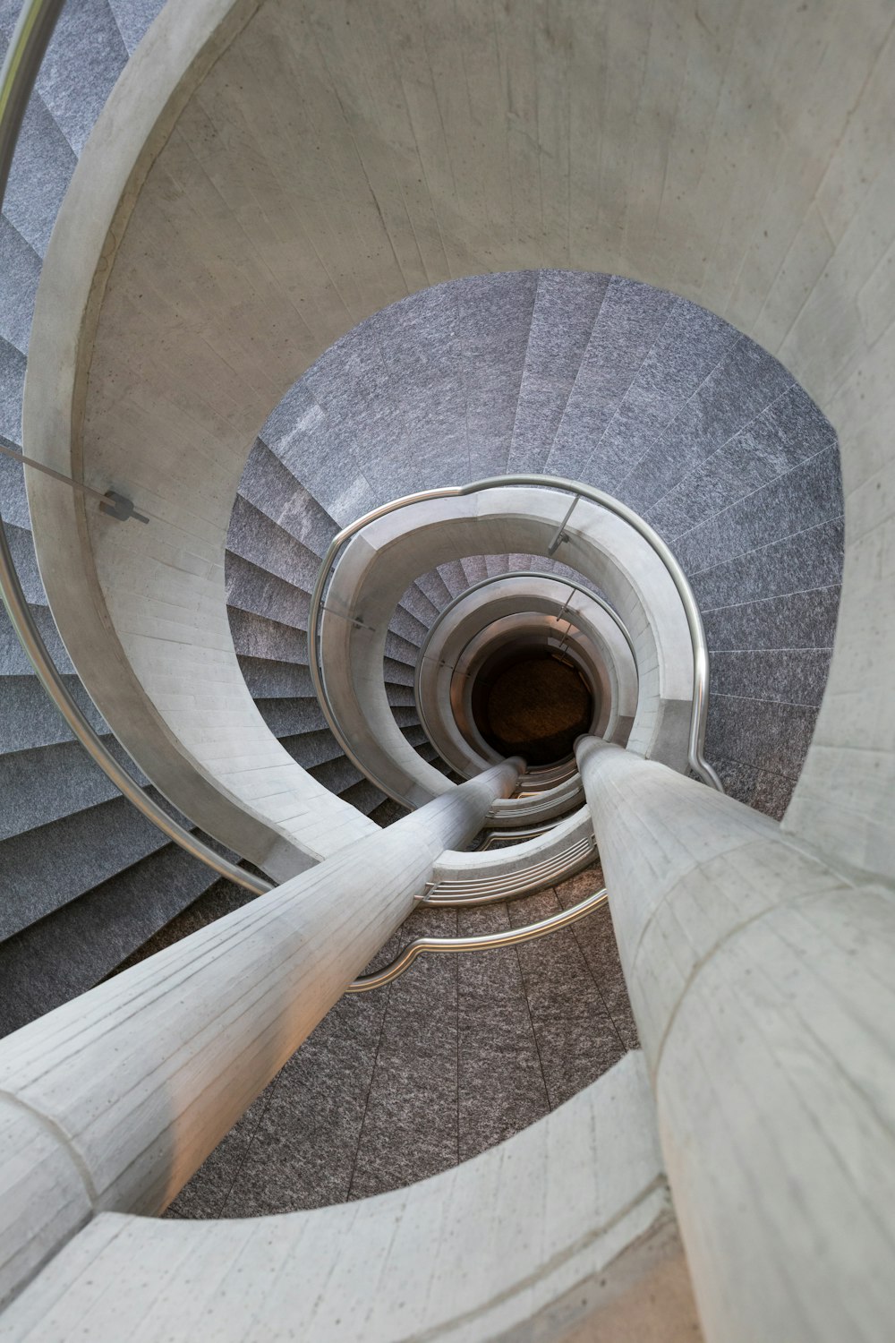 gray spiral staircase with brown wooden railings