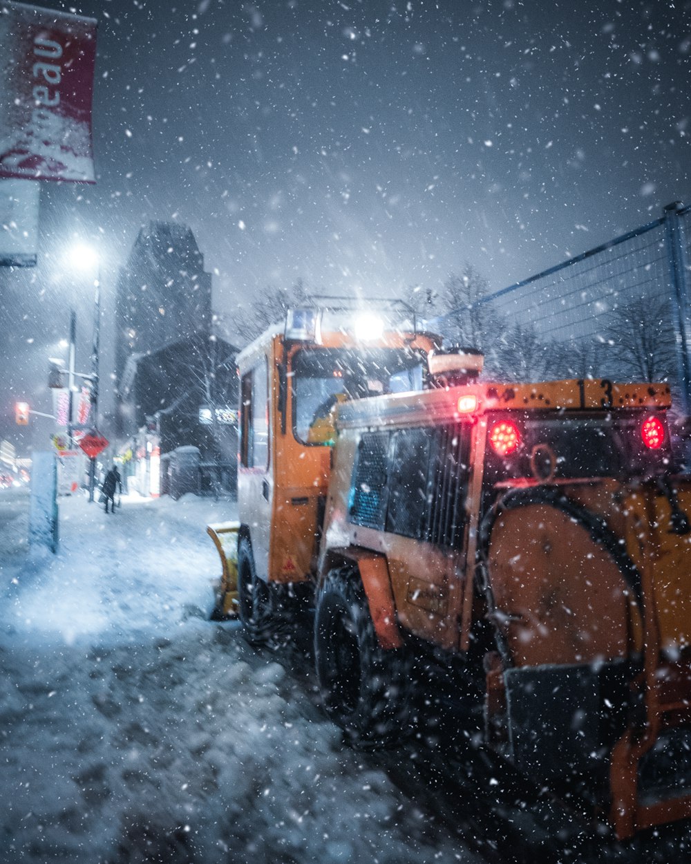 日中の雪に覆われた地面の赤と黒の重機