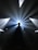 A silhouette of a person wearing headphones stands in front of a DJ setup. Bright, dramatic beams of light radiate outward from behind, creating a dynamic and energetic atmosphere.