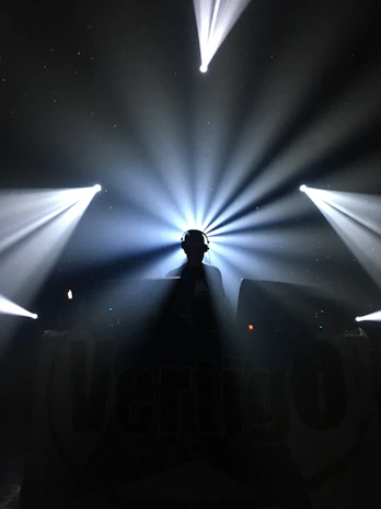Elegant black and white minimalist logo silhouette of a DJ with headphones.