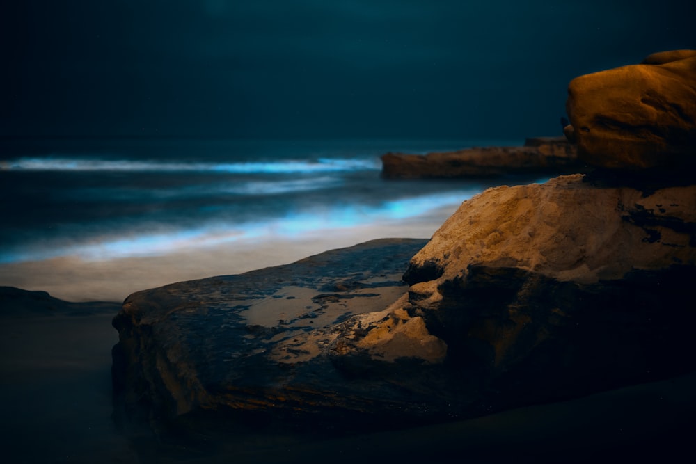 brown rock formation near body of water during daytime