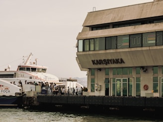 white and green concrete building near body of water during daytime