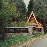 The rustic wooden exterior of the A-frame cabin nestled among tall pine trees.