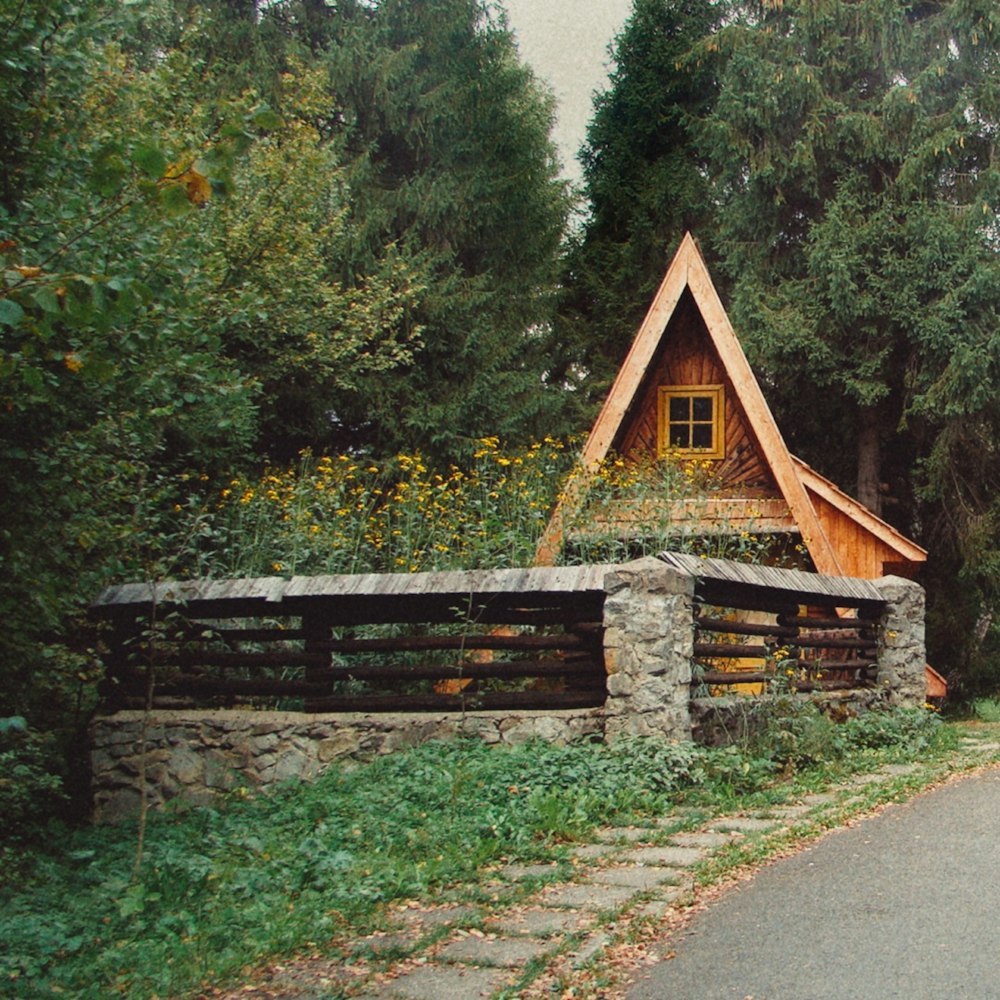 brown wooden house near green trees during daytime