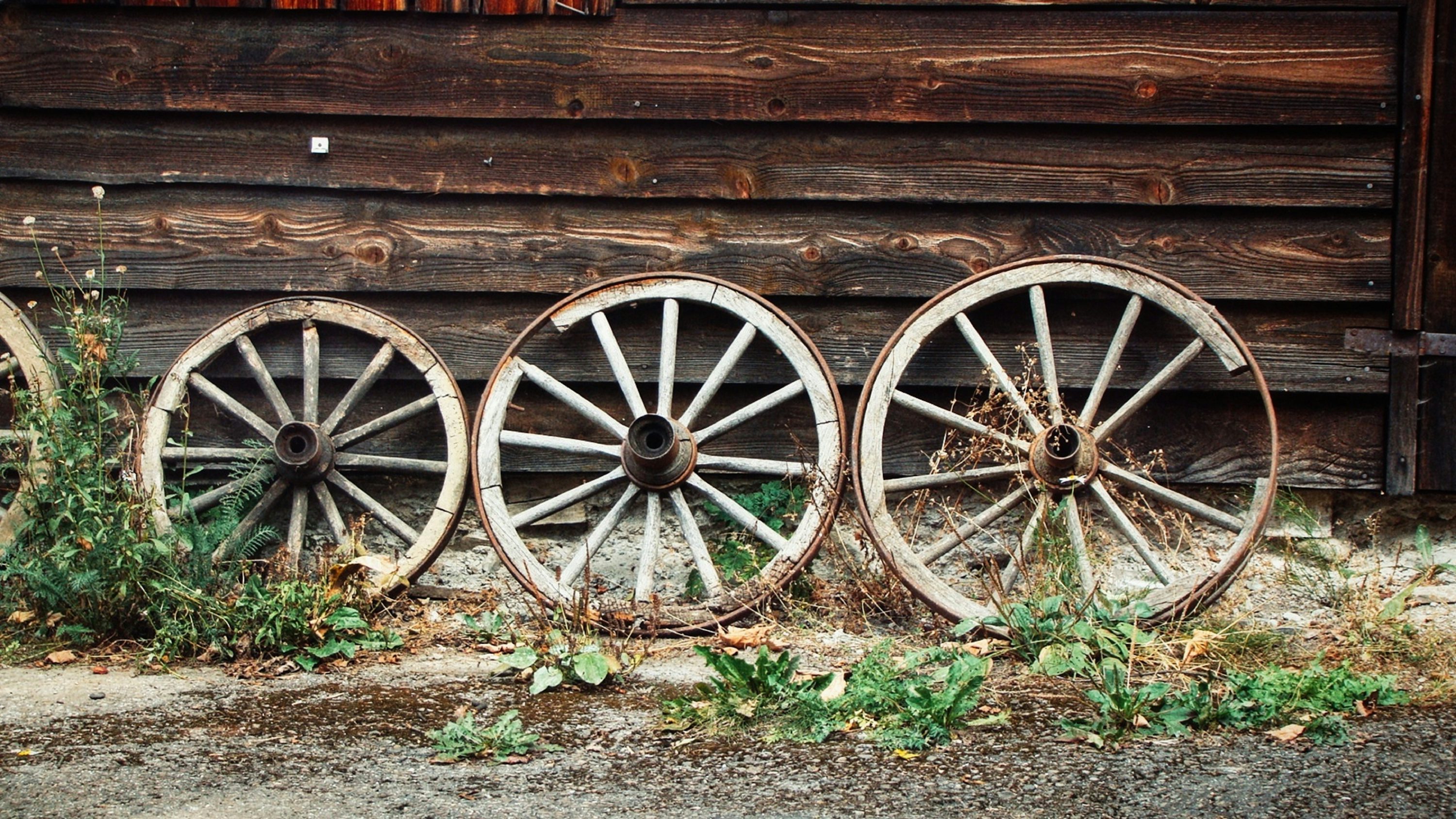 roue noire appuyée sur un mur en bois brun