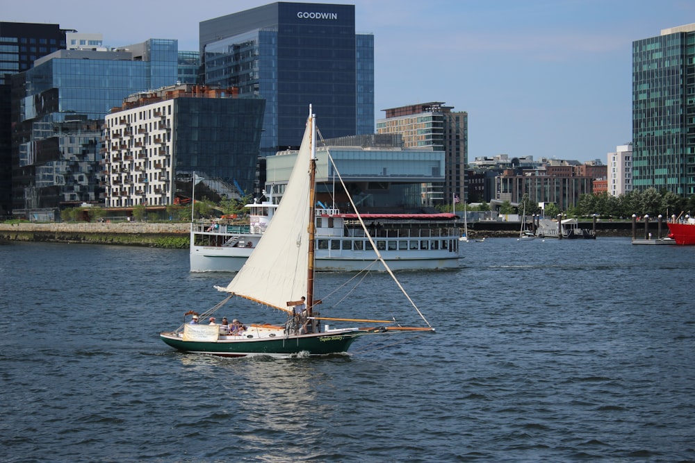 white and black boat on water near city buildings during daytime