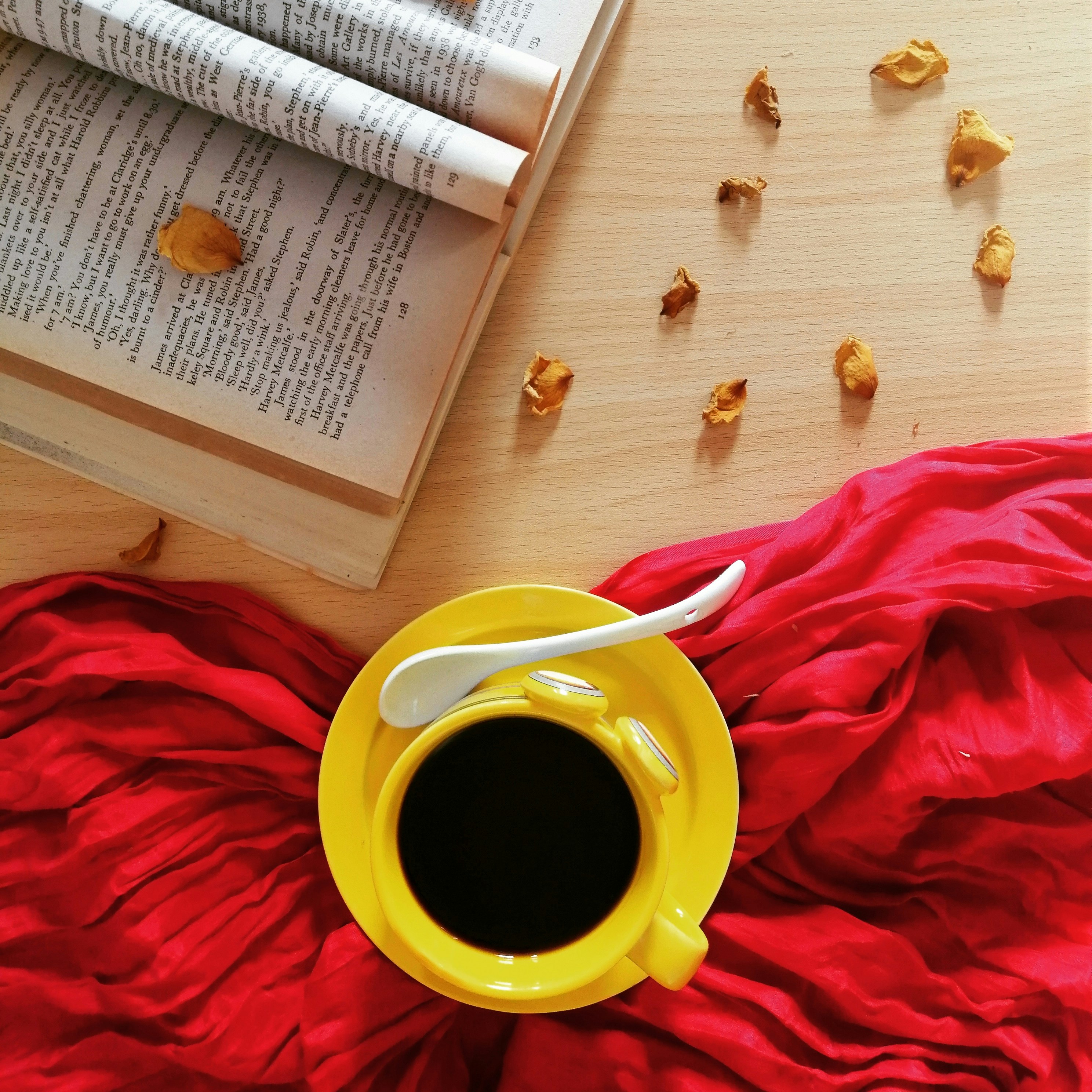 red ceramic mug on brown wooden table