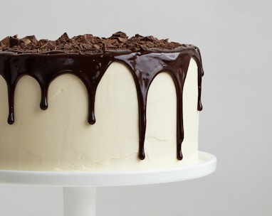 white cake with chocolate syrup on white ceramic plate