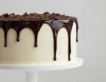 white cake with chocolate syrup on white ceramic plate