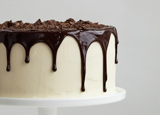 white cake with chocolate syrup on white ceramic plate