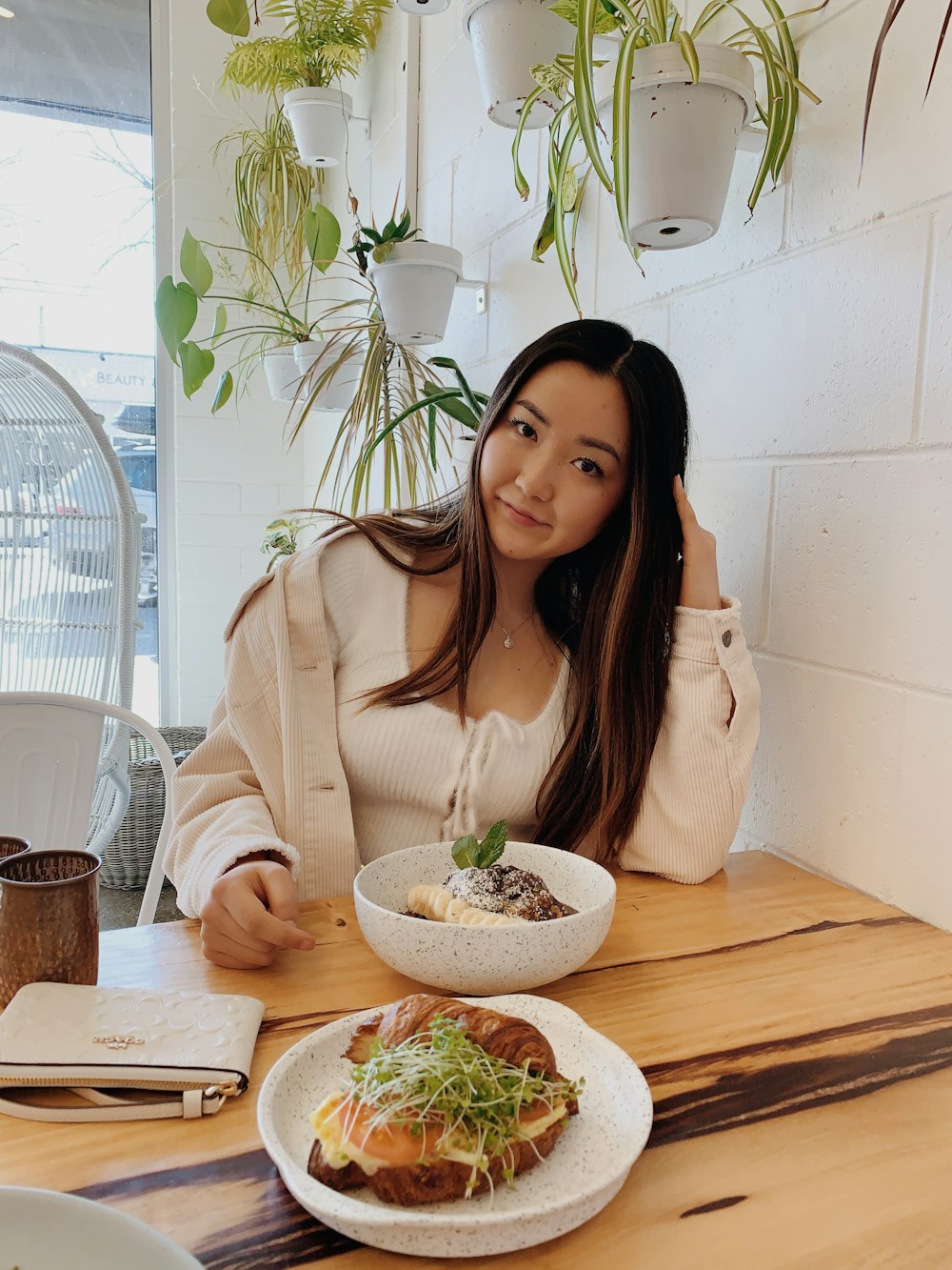 woman in beige blazer sitting by the table