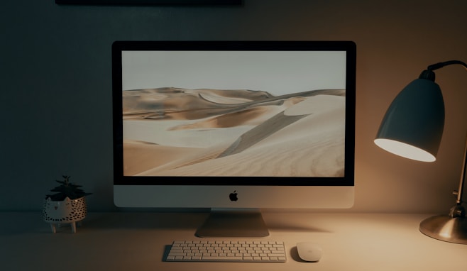 silver imac on brown wooden table