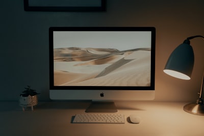 silver imac on brown wooden table display google meet background