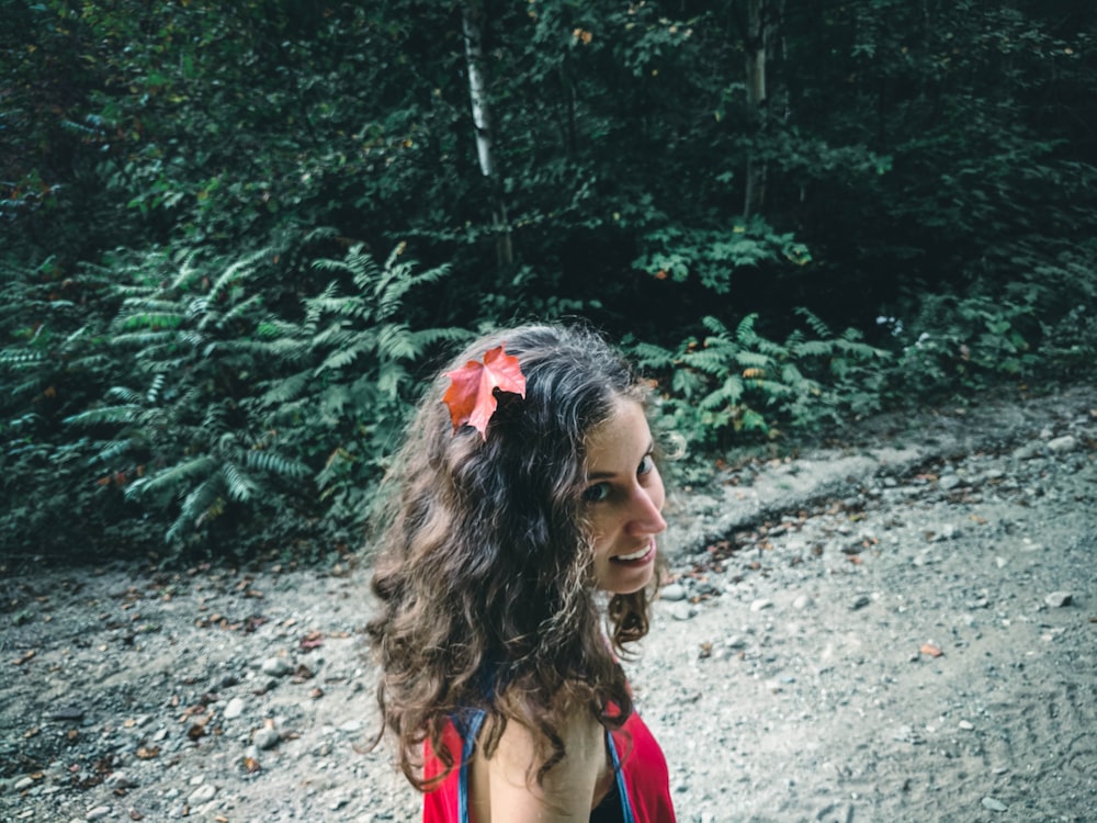 woman in pink tank top standing near green trees during daytime