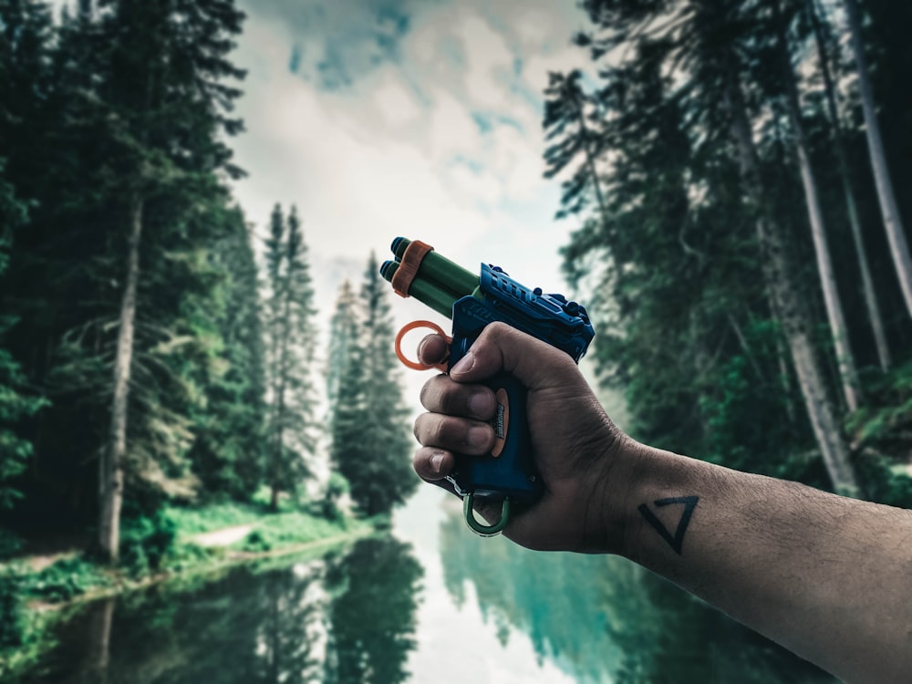 person holding green and black toy gun