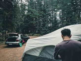 Close-up of the inflatable airframe being quickly set up by a camper in a forest.