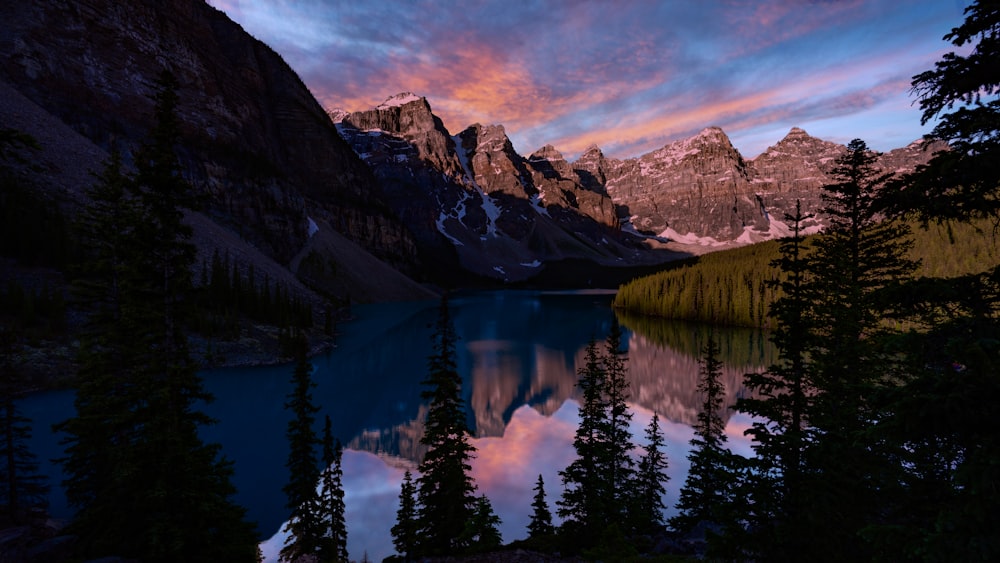 lake near mountain under blue sky during daytime