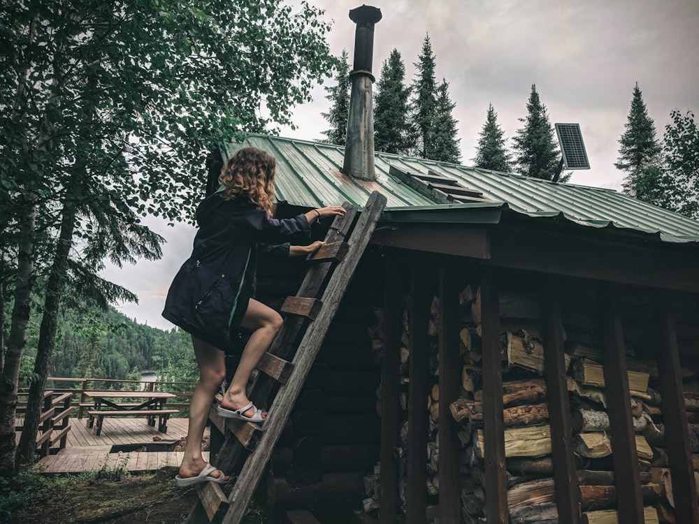Donna in maglietta nera seduta su scale di legno marroni