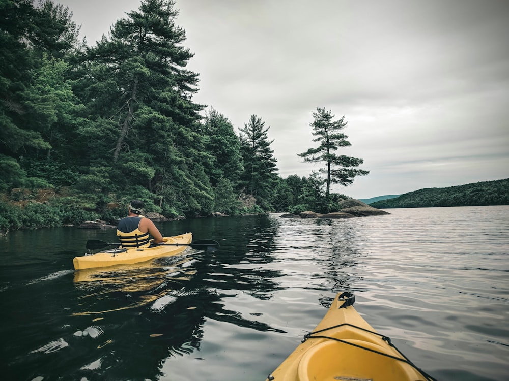 Personne conduisant un kayak jaune sur le lac pendant la journée