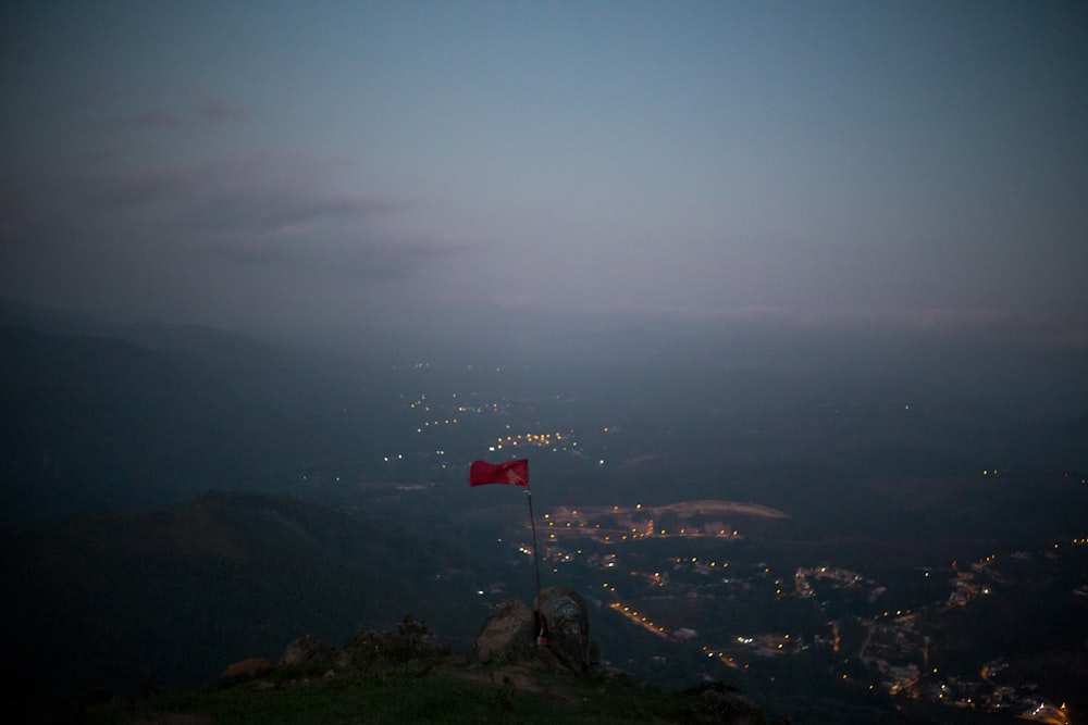red and white flag on top of mountain during daytime