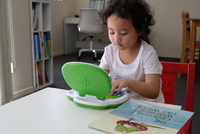 girl in pink crew neck t-shirt holding green plastic bowl
