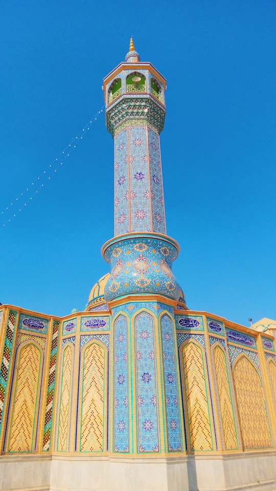 green and yellow concrete building under blue sky during daytime in Qom Iran