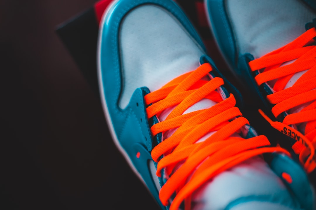 person wearing blue and orange low top sneakers