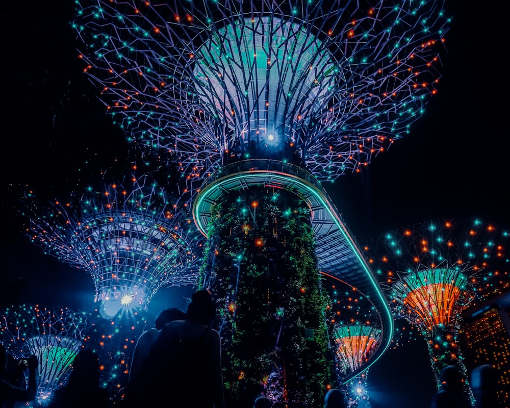 people standing near lighted ferris wheel during night time