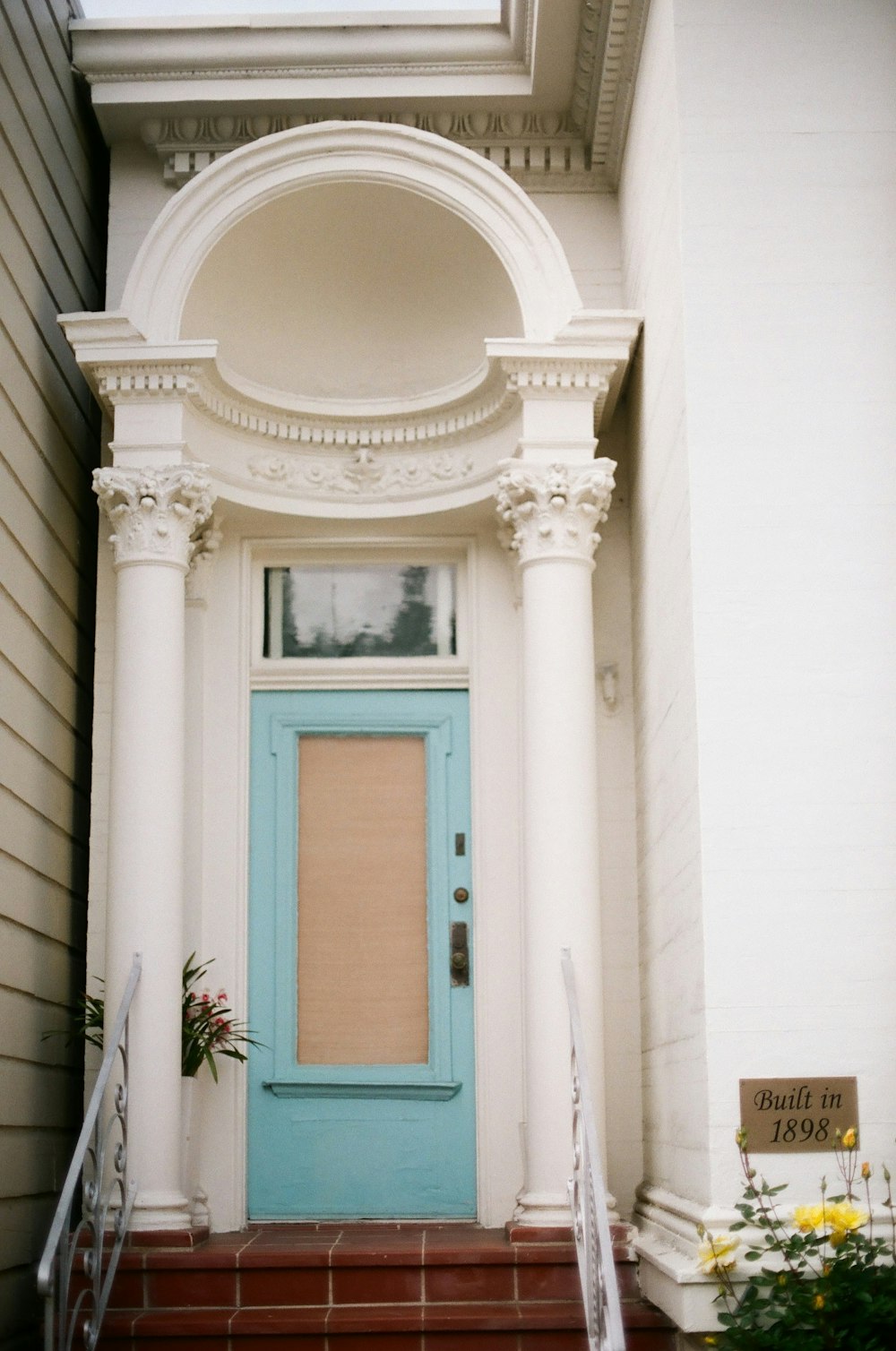 blue wooden door on white concrete building