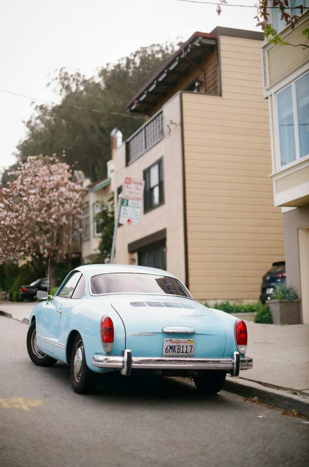 Porsche 911 bleue et blanche garée dans la rue pendant la journée