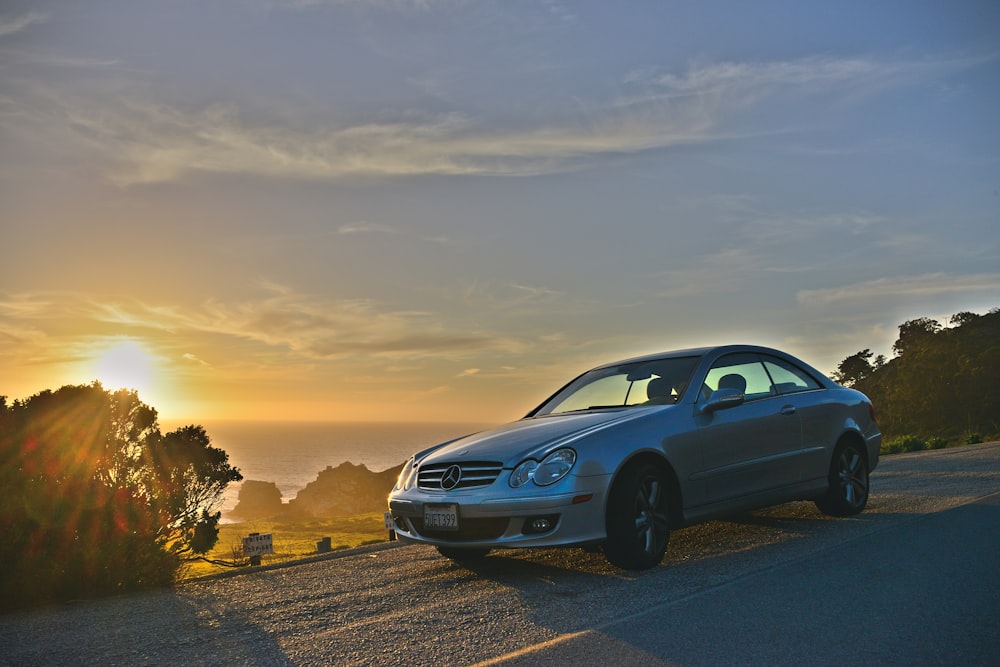 black sedan on road during sunset