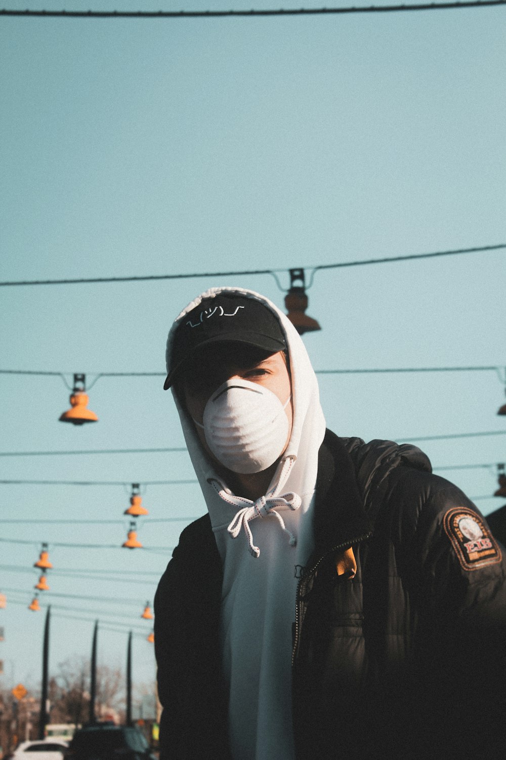 man in black jacket wearing white mask