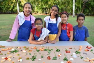 A cheerful group of children enjoying colorful fresh fruit snacks outdoors, surrounded by vibrant healthy foods.