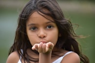 A playful snapshot of a cam girl blowing kisses towards the camera.