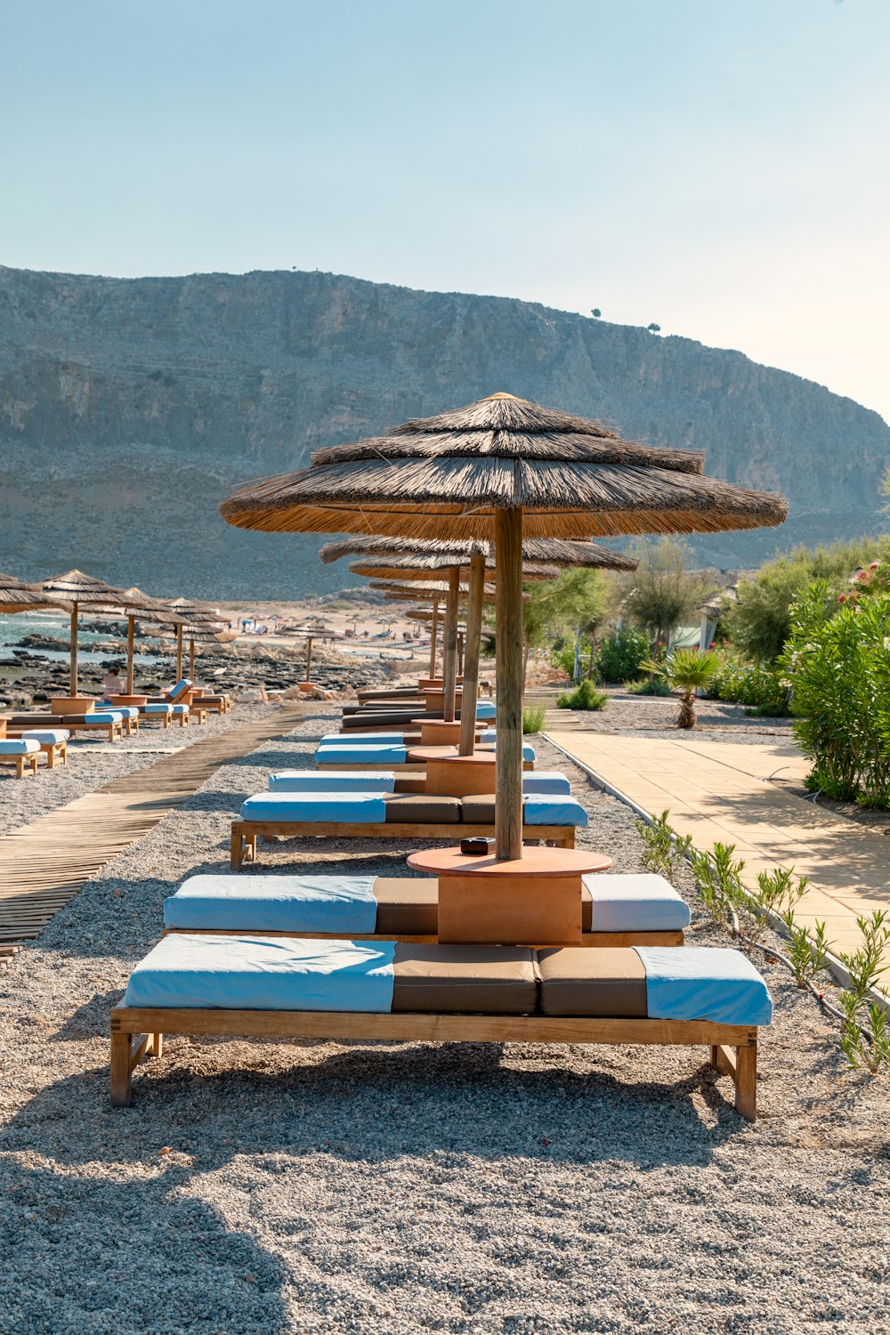 brown wooden outdoor table with chairs on beach during daytime