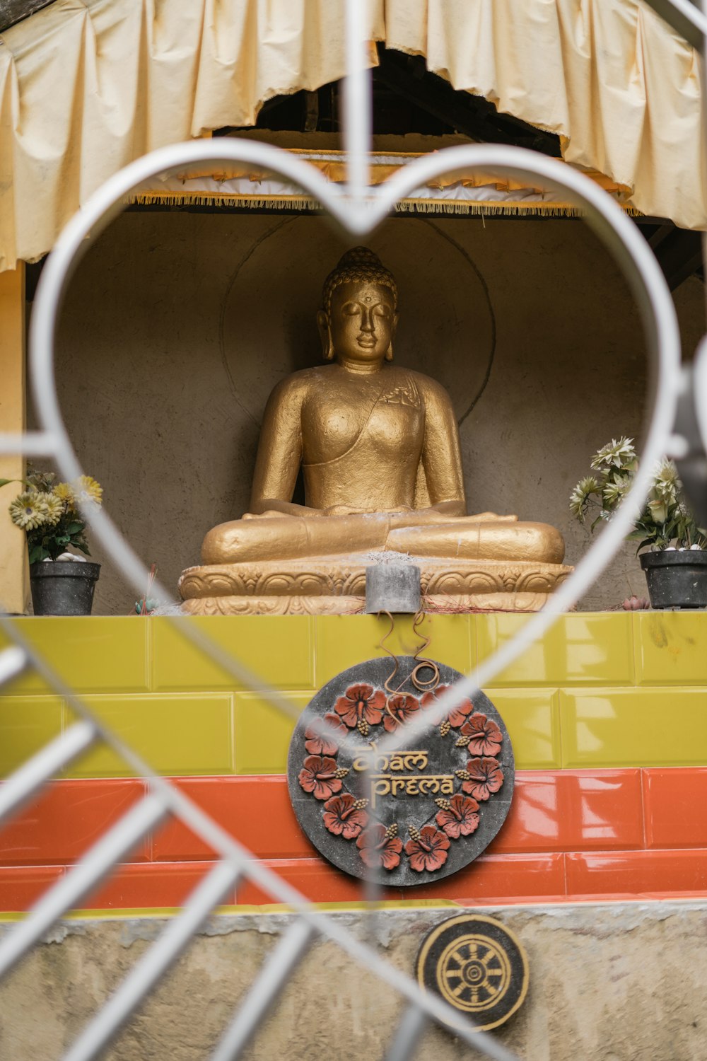 Goldene Buddha-Statue mit rot-weißem Rundrahmen