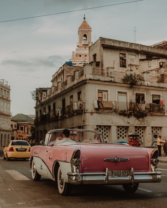 red and white vintage car on road near building during daytime in Habana Cuba