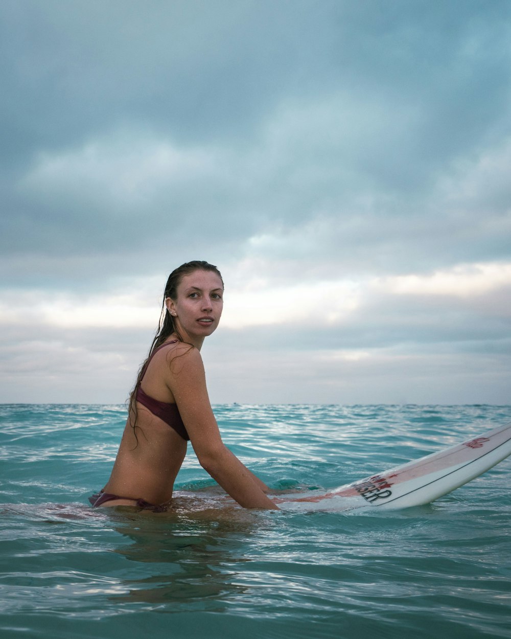 woman in black bikini top on body of water during daytime