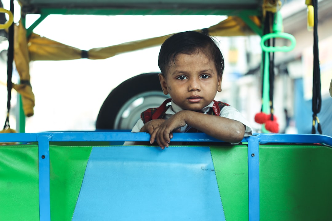 boy in red shirt on green and black vehicle