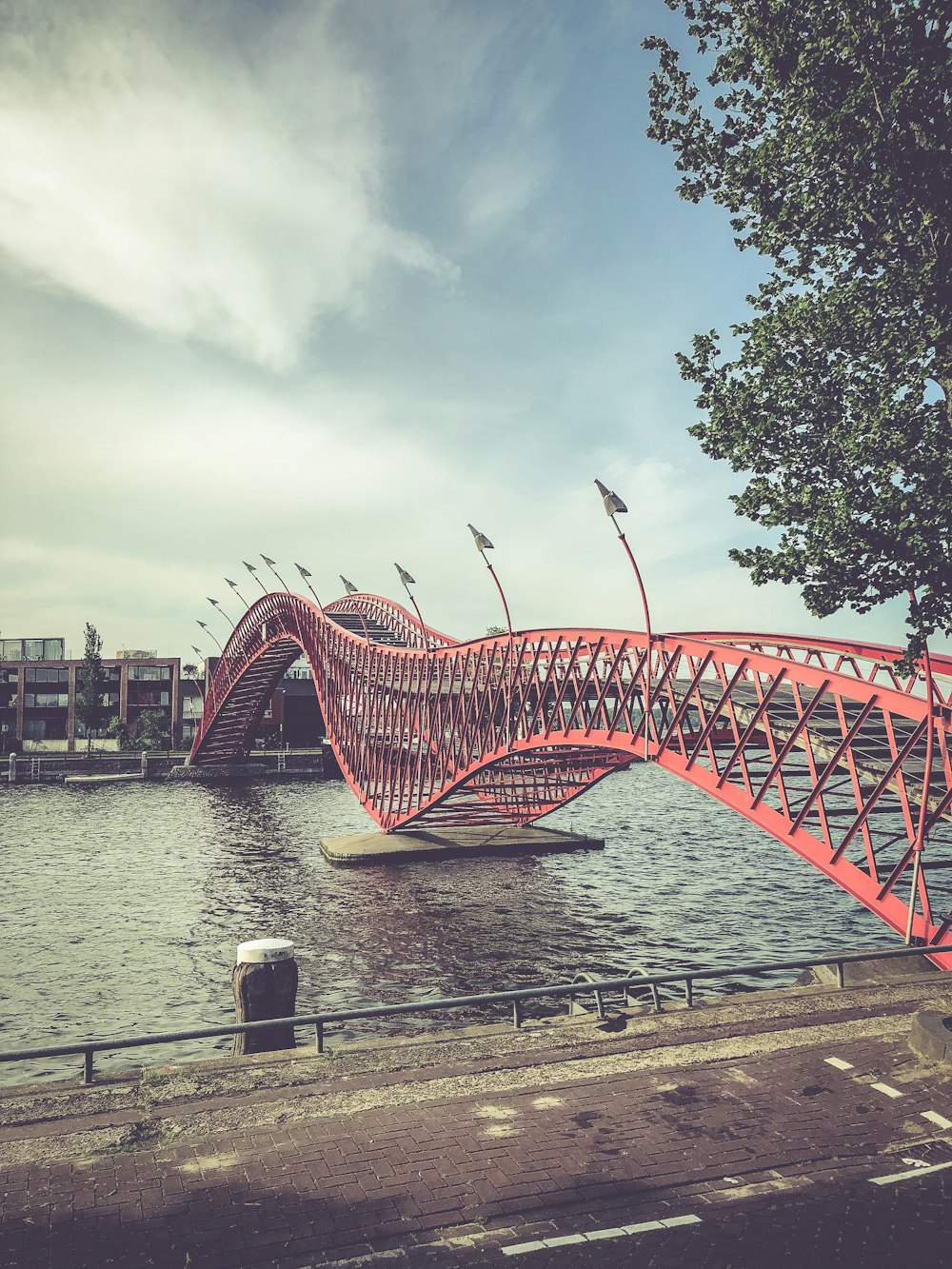 Rote Metallbrücke über den Fluss unter blauem Himmel tagsüber