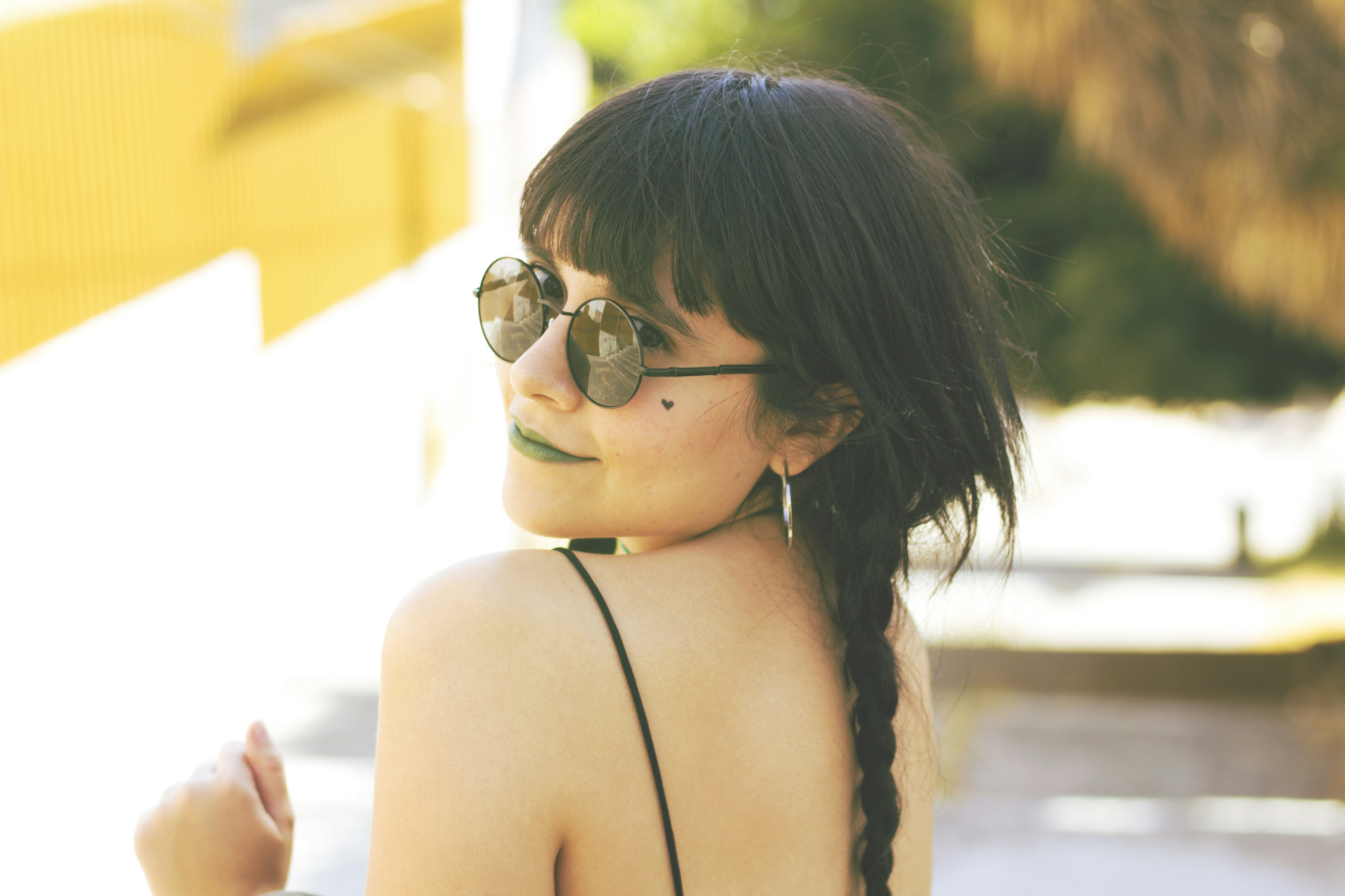woman in black spaghetti strap top wearing black sunglasses