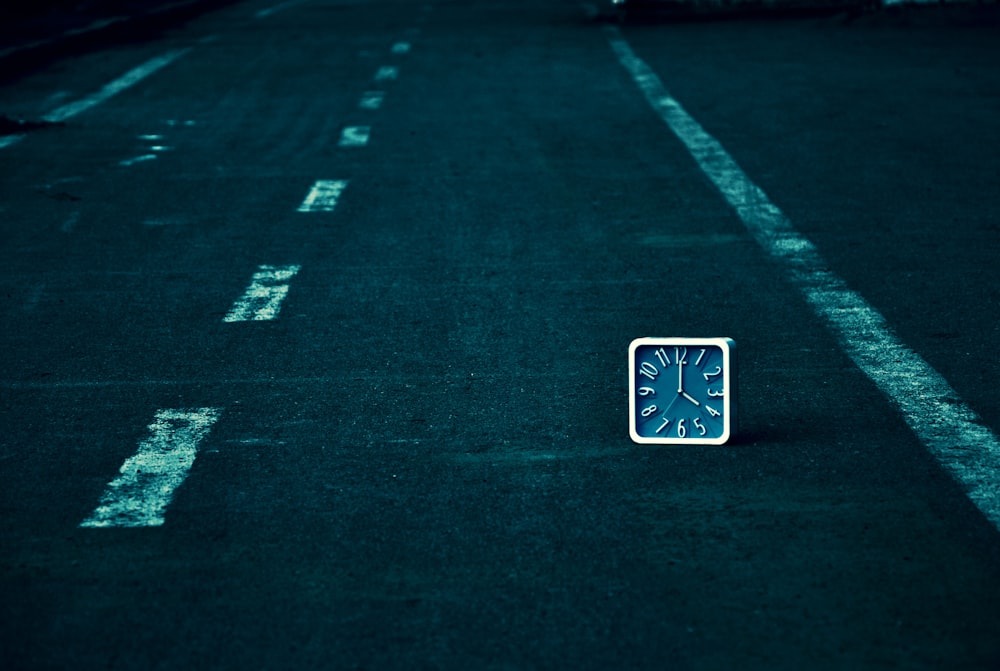 white and black arrow sign on green field