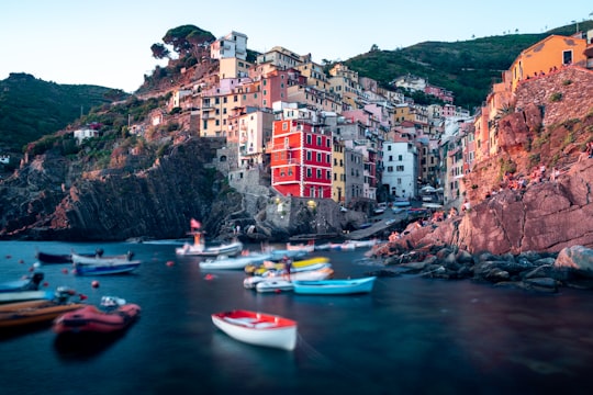 white and red boat on water near brown concrete building during daytime in Parco Nazionale delle Cinque Terre Italy