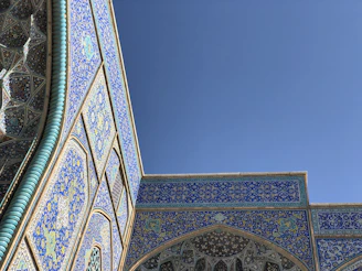 The intricate tilework of Herat's historic Friday Mosque under a clear blue sky