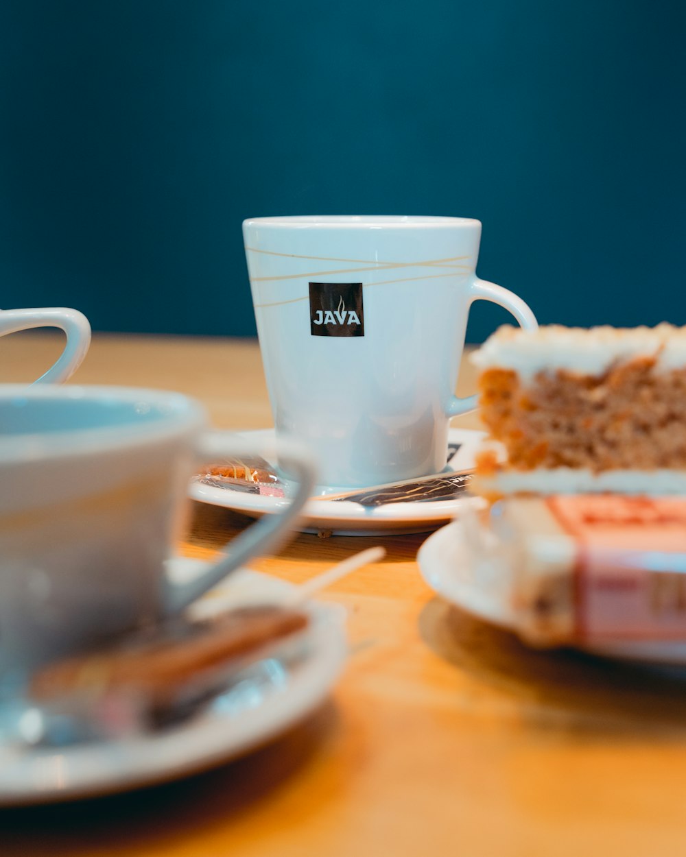 Tasse en céramique blanche sur soucoupe en céramique blanche à côté du pain sur assiette en céramique blanche