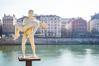 woman statue near body of water during daytime