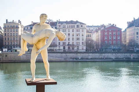 woman statue near body of water during daytime
