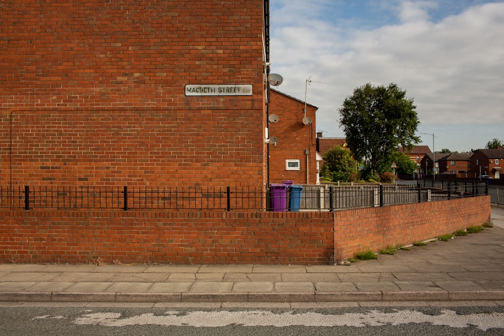 brown brick wall near green trees during daytime